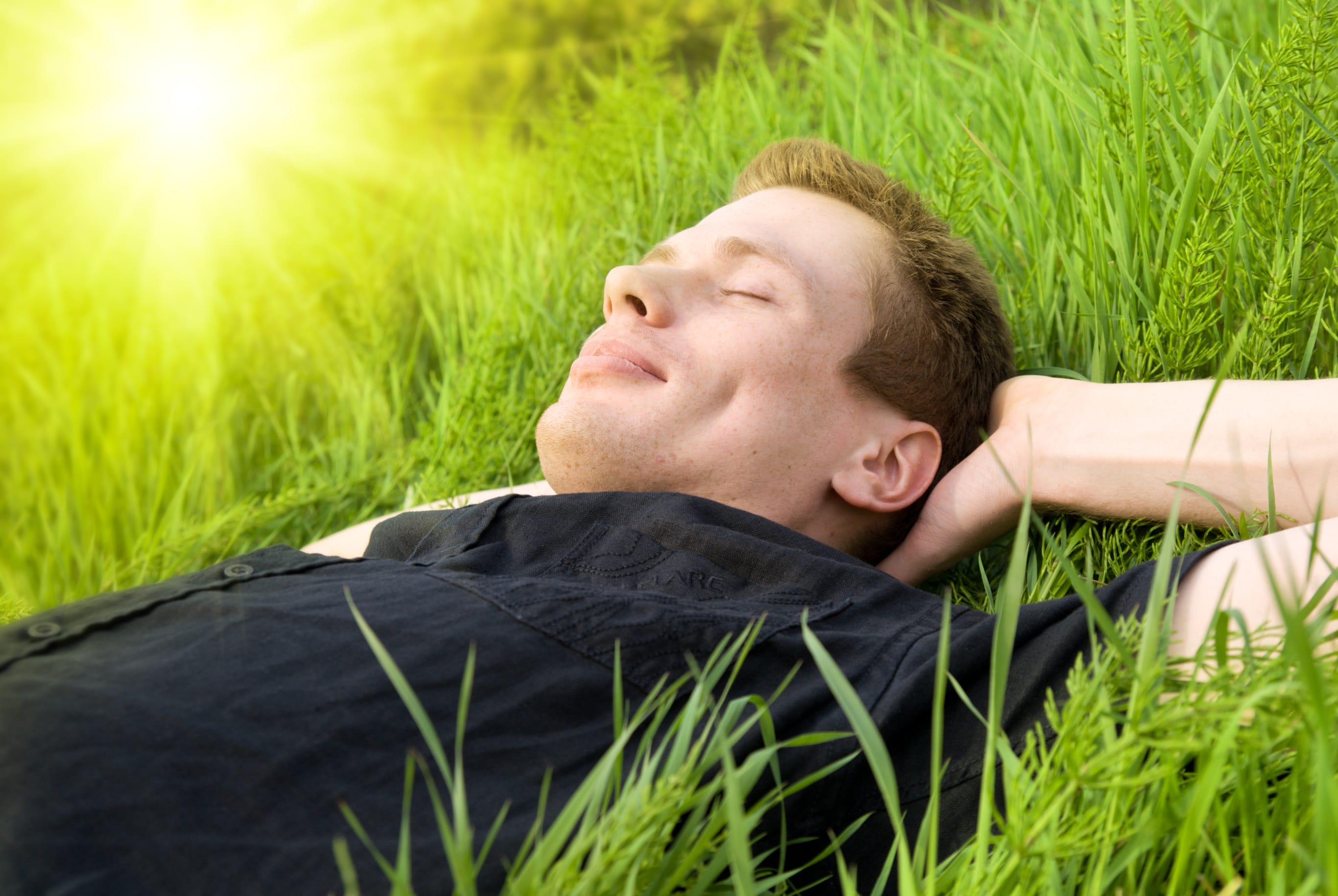 Глотки воздуха нормально дышим живая травинка человек. Человек лежит на траве. Мужчина лежит на траве. Парень лежит на траве. Человек отдыхает.